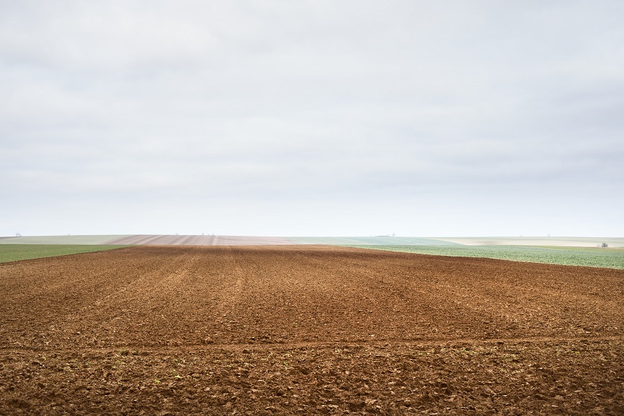 Panoramic scenery of the plowed agricultural field. Dramatic sky. France, Europe. Autumn, seasons, warm winter, climate change, tourism, farm industry